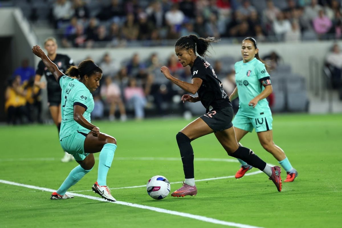 Oct 6, 2025; Los Angeles, California, USA;  Angel City FC forward Sveindis Jonsdottir (32) dribbles the ball against Kansas City Current defender Elizabeth Ball (7) during the first half at BMO Stadium. Mandatory Credit: Kiyoshi Mio-Imagn Images