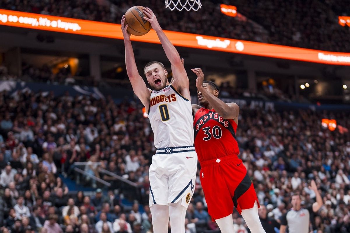 Oct 6, 2025; Vancouver, British Columbia, CAN; Toronto Raptors guard Ochai Agbaji (30) battles for the rebound with Denver Nuggets guard Christian Braun (0) in the first half at Rogers Arena. Mandatory Credit: Bob Frid-Imagn Images
