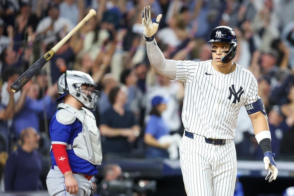 Oct 7, 2025; Bronx, New York, USA; New York Yankees outfielder Aaron Judge (99) flips his bat after hitting a three-run home run in the fourth inning against the Toronto Blue Jays during game three of the ALDS round for the 2025 MLB playoffs at Yankee Stadium. Mandatory Credit: Wendell Cruz-Imagn Images