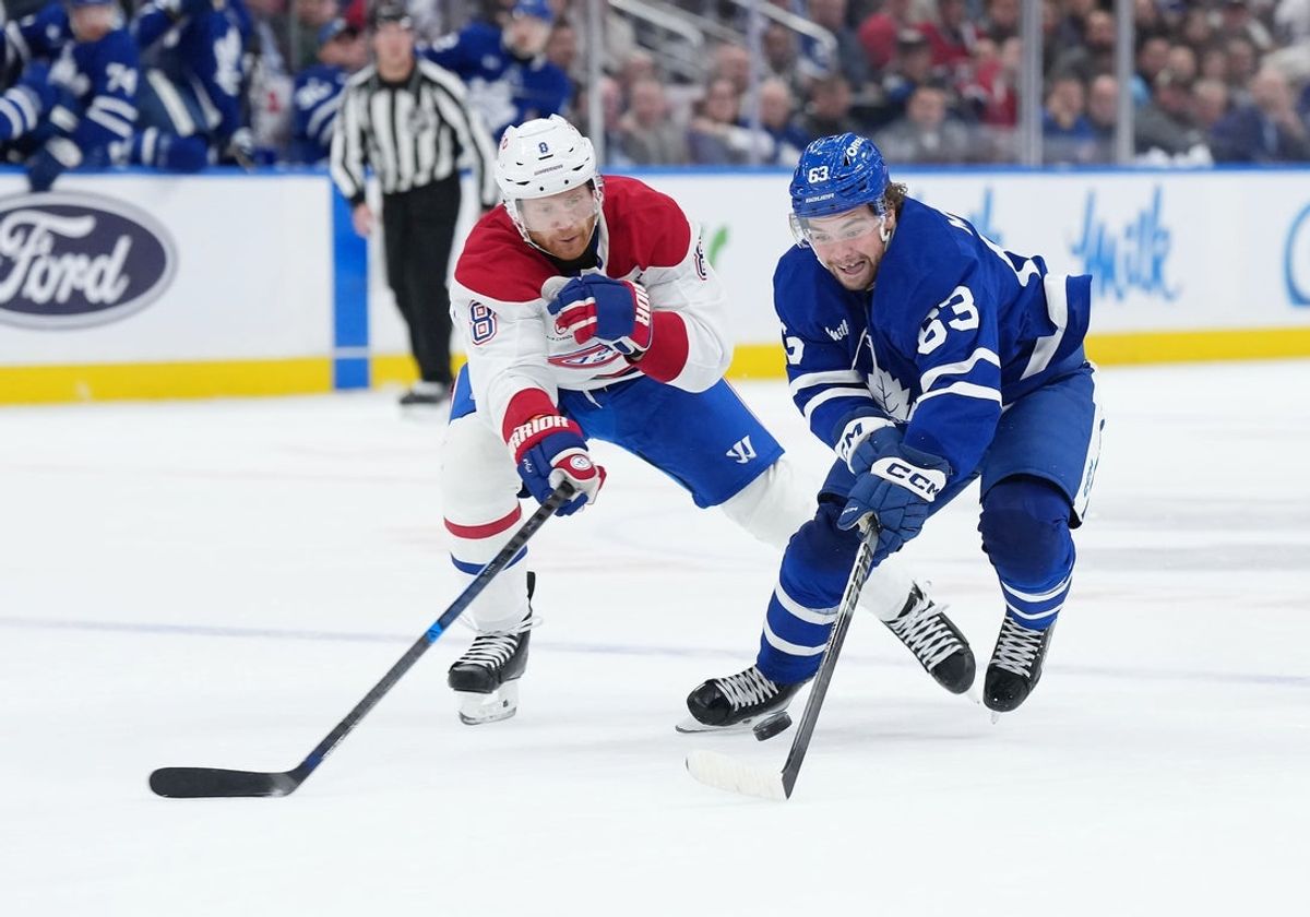 Oct 8, 2025; Toronto, Ontario, CAN;  Toronto Maple Leafs left wing Matias MacCelli (63) battles for the puck with Montreal Canadiens defenseman Mike Matheson (8) during the first period at Scotiabank Arena. Mandatory Credit: Nick Turchiaro-Imagn Images
