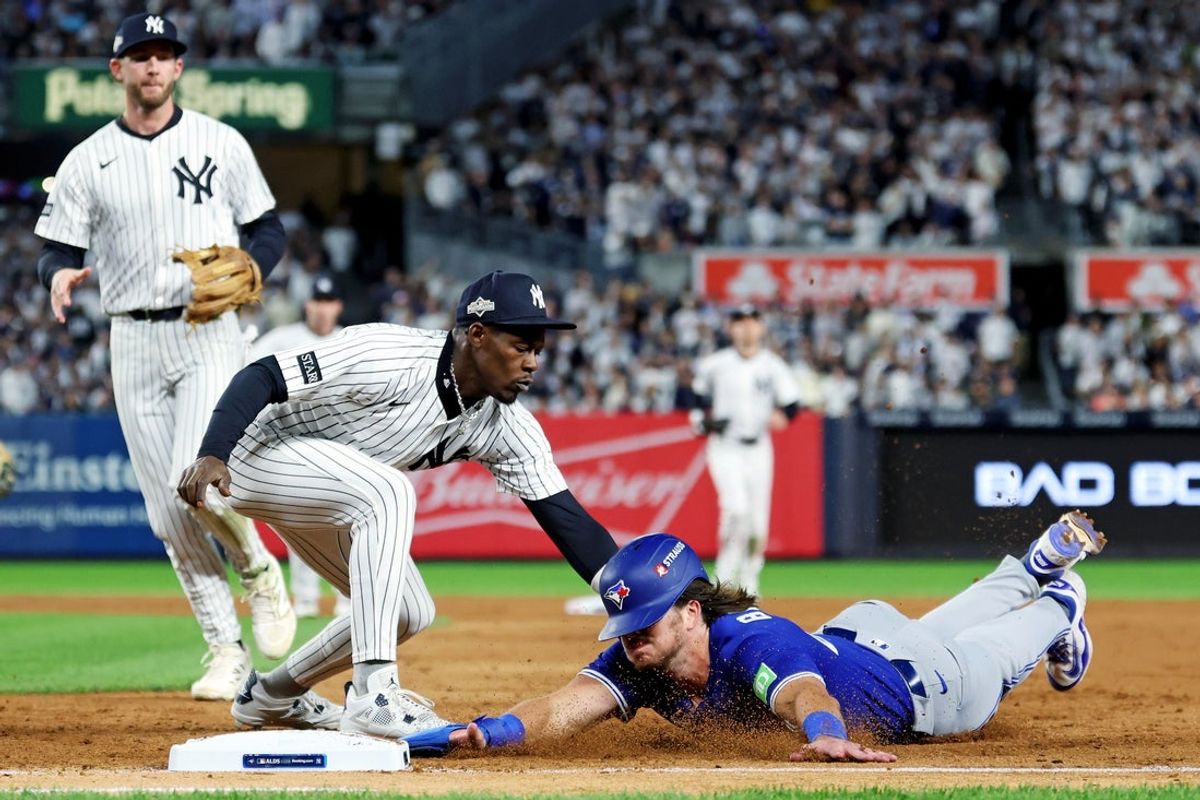 Oct 8, 2025; Bronx, New York, USA; New York Yankees second baseman Jazz Chisholm Jr. (13) tags out Toronto Blue Jays third baseman Addison Barger (47) at first base during the sixth inning during game four of the ALDS round for the 2025 MLB playoffs at Yankee Stadium. Mandatory Credit: Vincent Carchietta-Imagn Images