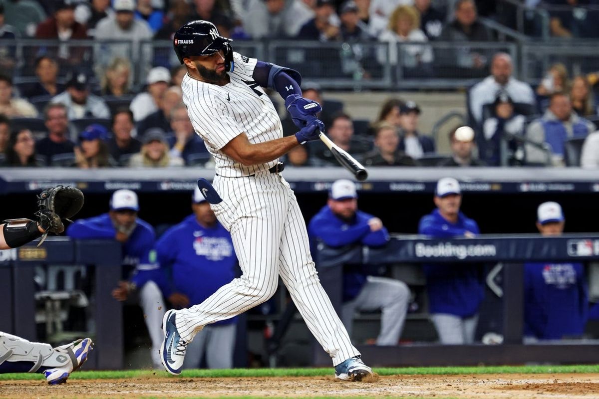 Oct 8, 2025; Bronx, New York, USA; New York Yankees third baseman Amed Rosario (14) hits a single during the seventh inning against the Toronto Blue Jays during game four of the ALDS round for the 2025 MLB playoffs at Yankee Stadium. Mandatory Credit: Vincent Carchietta-Imagn Images