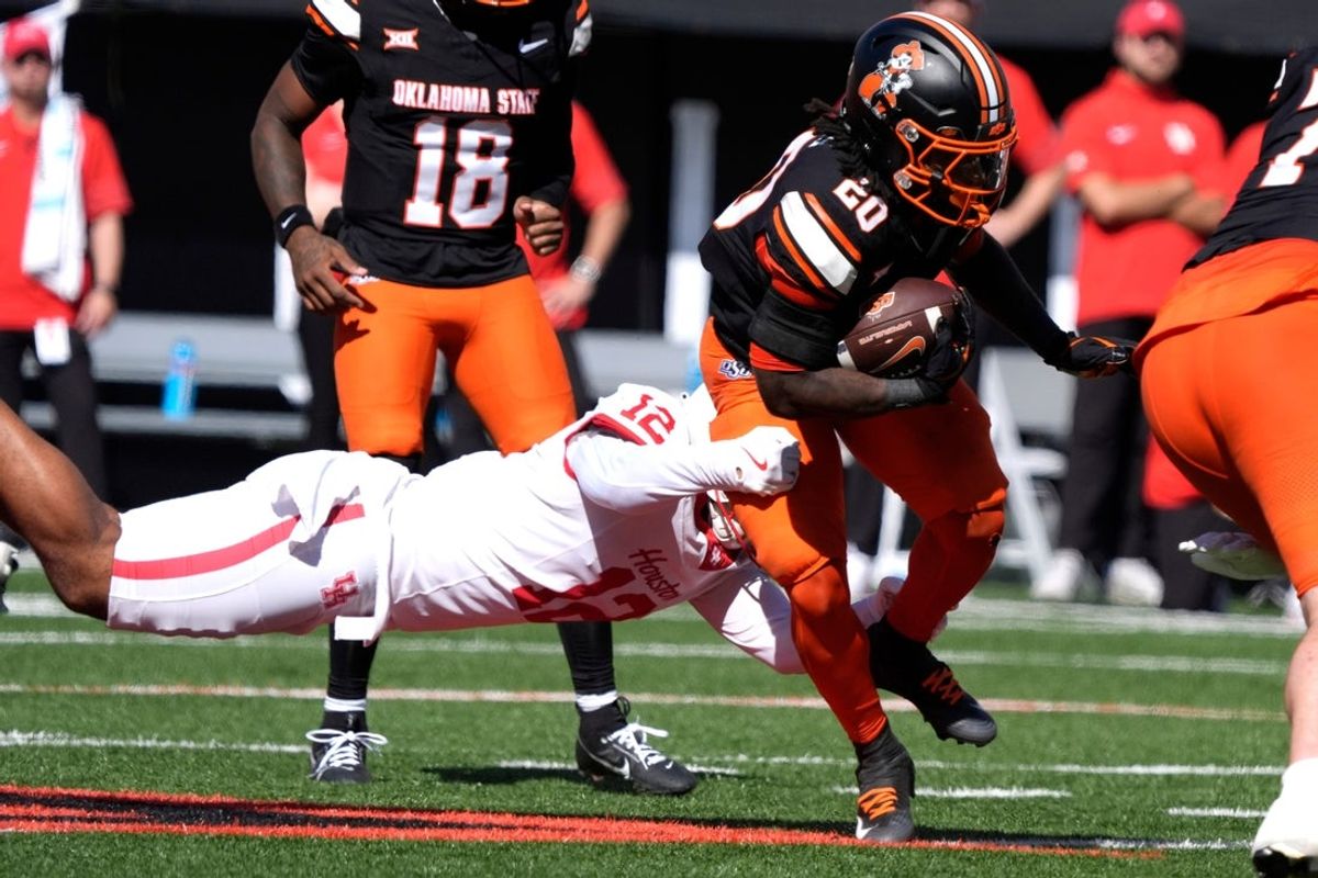Oklahoma State Cowboys running back Rodney Fields Jr. (20) is brought down by Houston Cougars linebacker Sione Fotu (12) during a college football game between the Oklahoma State Cowboys (OSU) and the Houston Cougars at Boone Pickens Stadium in Stillwater, Okla., Saturday, Oct. 11, 2025.
