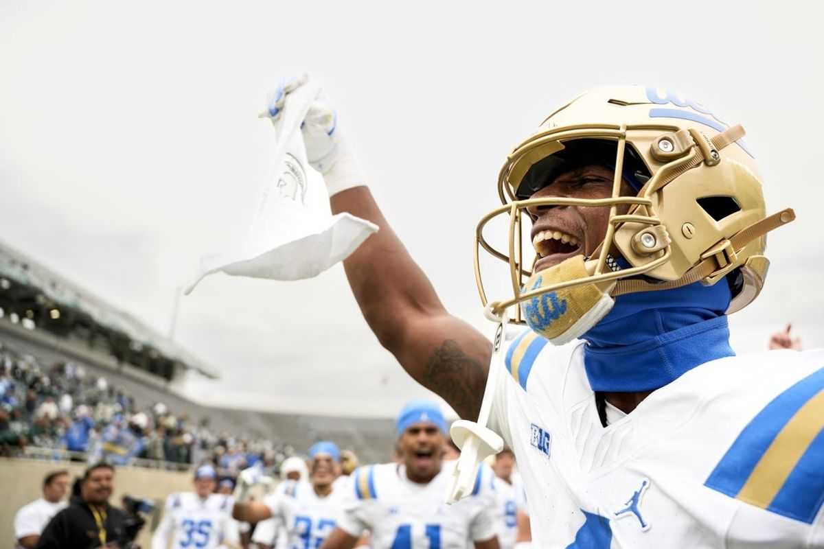 Oct 11, 2025; East Lansing, Michigan, USA; UCLA Bruins defensive back Key Lawrence (4) holds up a towel branding the Michigan State logo after beating the Spartans at Spartan Stadium. Mandatory Credit: Brendan Mullin-Imagn Images
