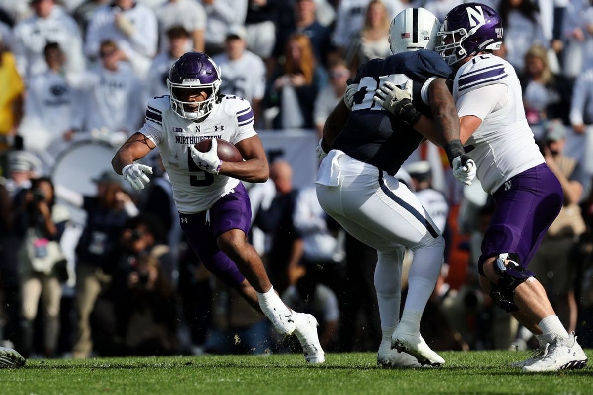 Oct 11, 2025; University Park, Pennsylvania, USA; Northwestern Wildcats running back Caleb Komolafe (5) runs with the ball during the first quarter against the Penn State Nittany Lions at Beaver Stadium. Mandatory Credit: Matthew O'Haren-Imagn Images