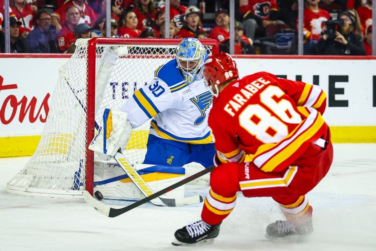 Oct 11, 2025; Calgary, Alberta, CAN; St. Louis Blues goaltender Joel Hofer (30) makes a save against Calgary Flames left wing Joel Farabee (86) during the second period at Scotiabank Saddledome. Mandatory Credit: Sergei Belski-Imagn Images