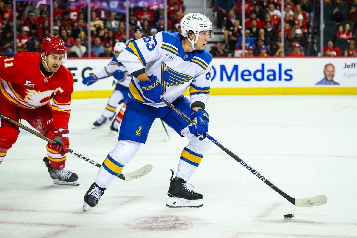 Oct 11, 2025; Calgary, Alberta, CAN; St. Louis Blues left wing Jake Neighbours (63) controls the puck against the Calgary Flames during the third period at Scotiabank Saddledome. Mandatory Credit: Sergei Belski-Imagn Images