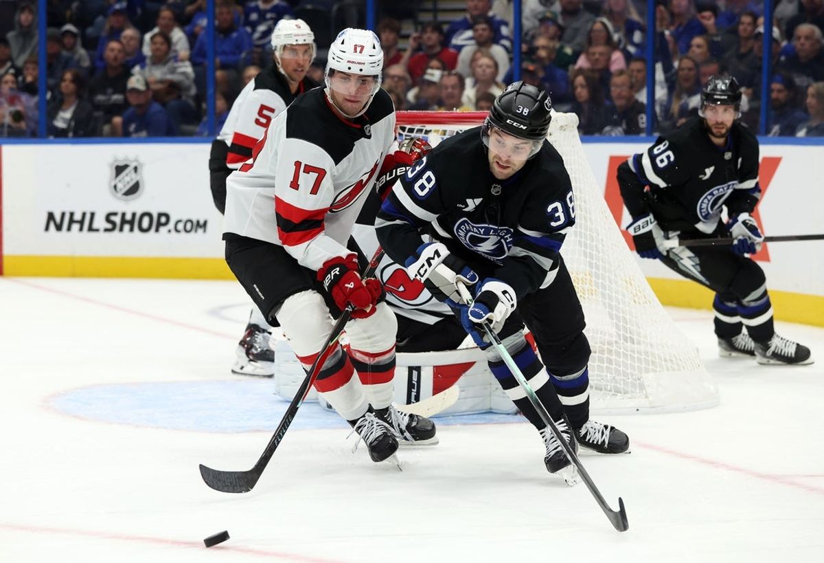 Oct 11, 2025; Tampa, Florida, USA; New Jersey Devils defenseman Simon Nemec (17) and Tampa Bay Lightning left wing Brandon Hagel (38) fight to control the puck during the first period at Benchmark International Arena. Mandatory Credit: Kim Klement Neitzel-Imagn Images