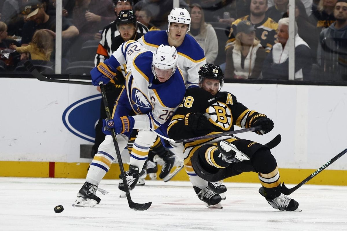 Oct 11, 2025; Boston, Massachusetts, USA; Buffalo Sabres defenseman Rasmus Dahlin (26) dumps Boston Bruins center Elias Lindholm (28) battling for the puck during the second period at TD Garden. Mandatory Credit: Winslow Townson-Imagn Images