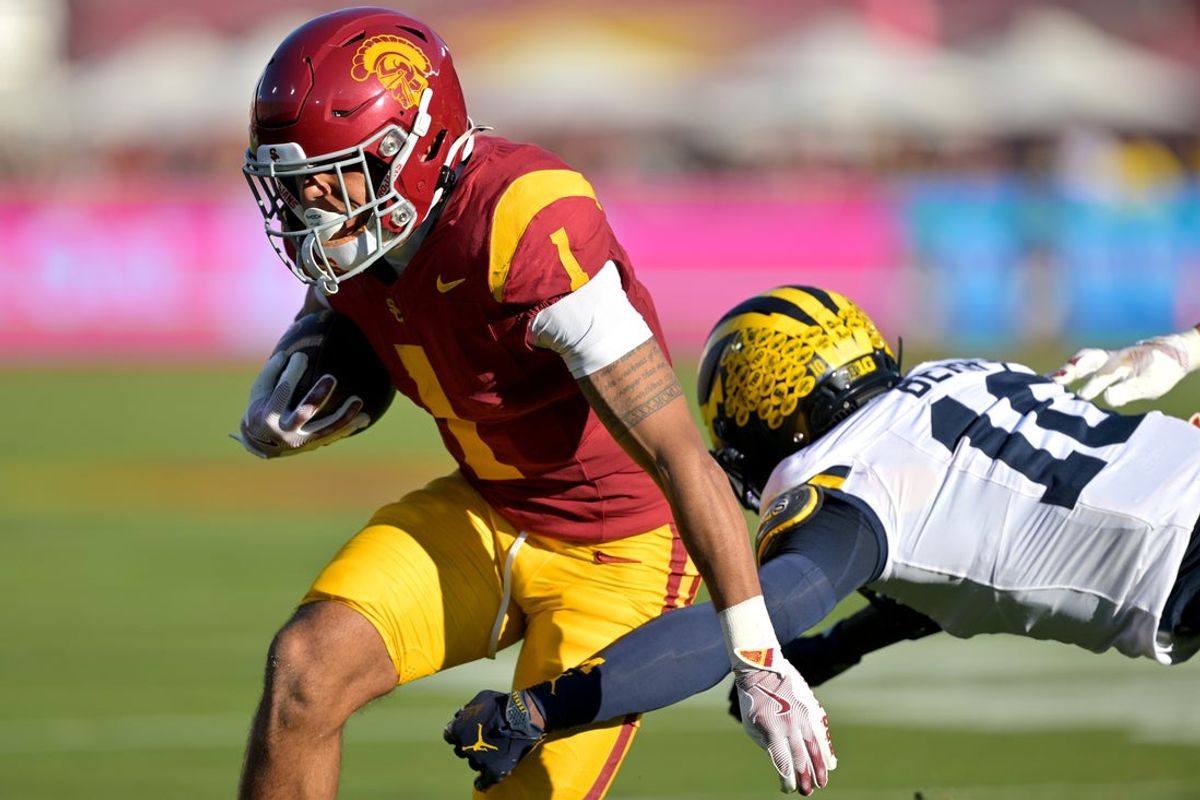 Oct 11, 2025; Los Angeles, California, USA;  USC Trojans running back Eli Sanders (1) runs past Michigan Wolverines defensive back Zeke Berry (10) for a first down in the first half at United Airlines Field at the Los Angeles Memorial Coliseum. Mandatory Credit: Jayne Kamin-Oncea-Imagn Images