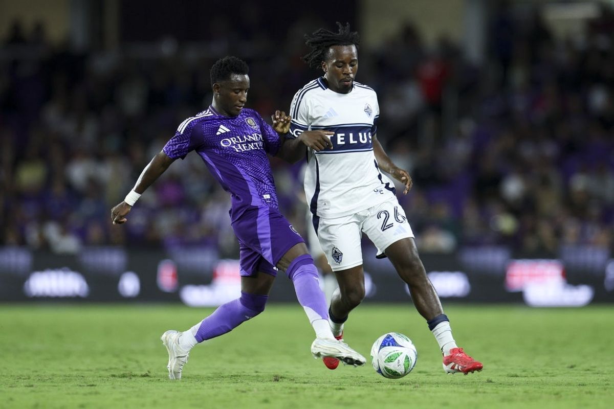 Oct 11, 2025; Orlando, Florida, USA; Orlando City forward Ivan Angulo (77) and Vancouver Whitecaps midfielder Jean-Claude Ngando (26) battle for the ball in the second half at Inter&Co Stadium. Mandatory Credit: Nathan Ray Seebeck-Imagn Images