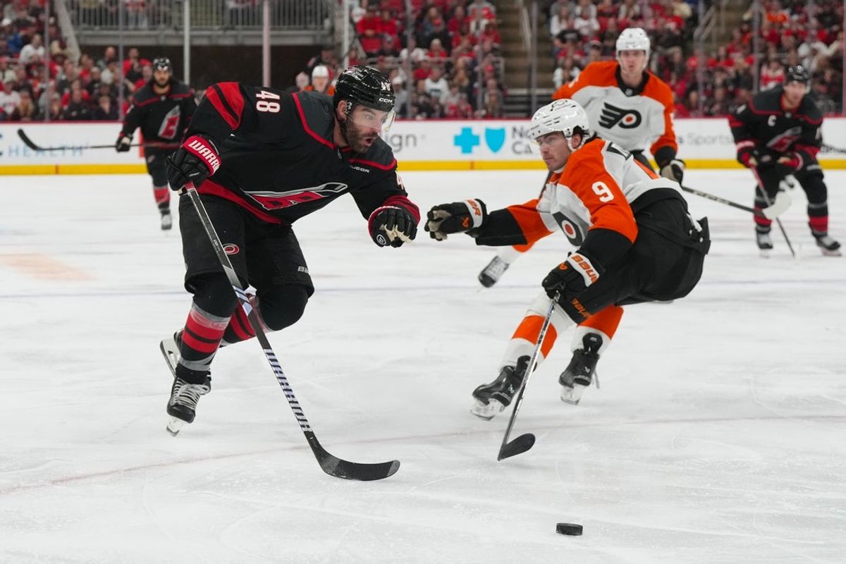 Oct 11, 2025; Raleigh, North Carolina, USA;  Carolina Hurricanes left wing Jordan Martinook (48) gets to the outside with the puck against Philadelphia Flyers defenseman Jamie Drysdale (9) during the third period at Lenovo Center. Mandatory Credit: James Guillory-Imagn Images