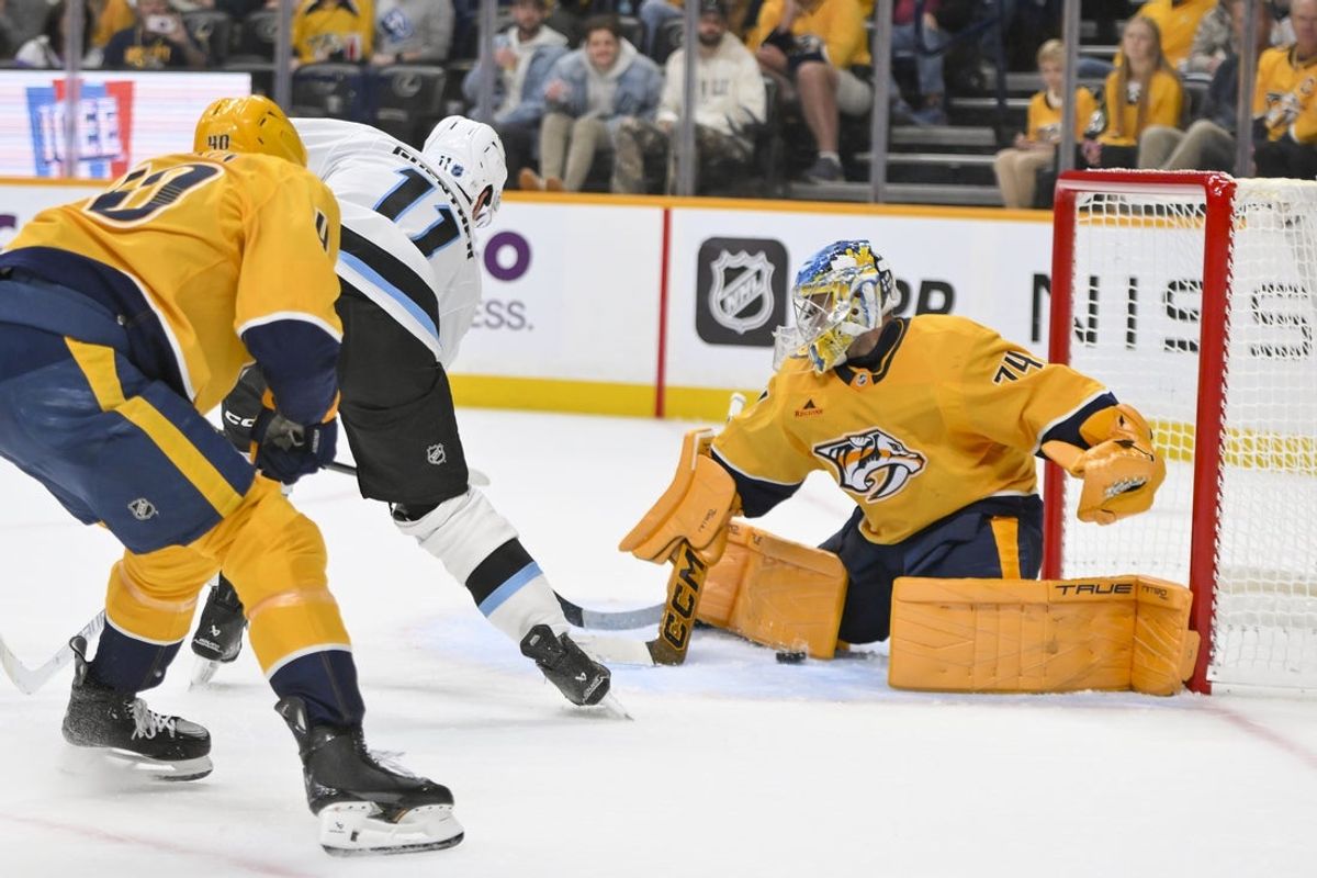 Oct 11, 2025; Nashville, Tennessee, USA;  Utah Mammoth right wing Dylan Guenther (11) scores the game winner past Nashville Predators goaltender Juuse Saros (74) during the overtime period at Bridgestone Arena. Mandatory Credit: Steve Roberts-Imagn Images