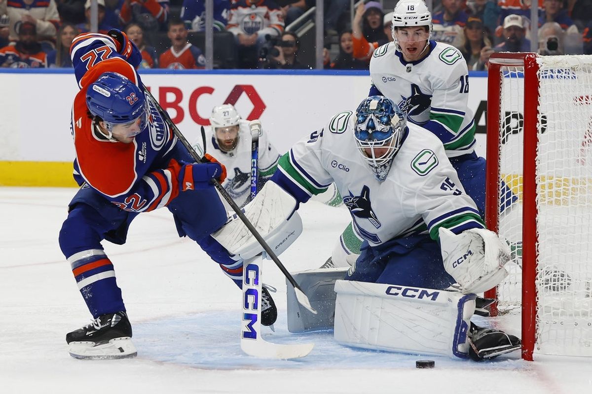 Oct 11, 2025; Edmonton, Alberta, CAN; Vancouver Canucks goaltender Thatcher Demko (35) makes a save on Edmonton Oilers forward Matt Savoie (22) during the first period at Rogers Place. Mandatory Credit: Perry Nelson-Imagn Images