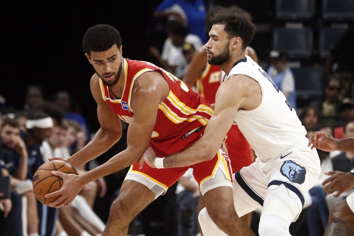 Oct 11, 2025; Memphis, Tennessee, USA; Atlanta Hawks guard Caleb Houstan (33) handles the ball as Memphis Grizzlies forward Tyler Burton (4) defends during the fourth quarter at FedExForum. Mandatory Credit: Petre Thomas-Imagn Images