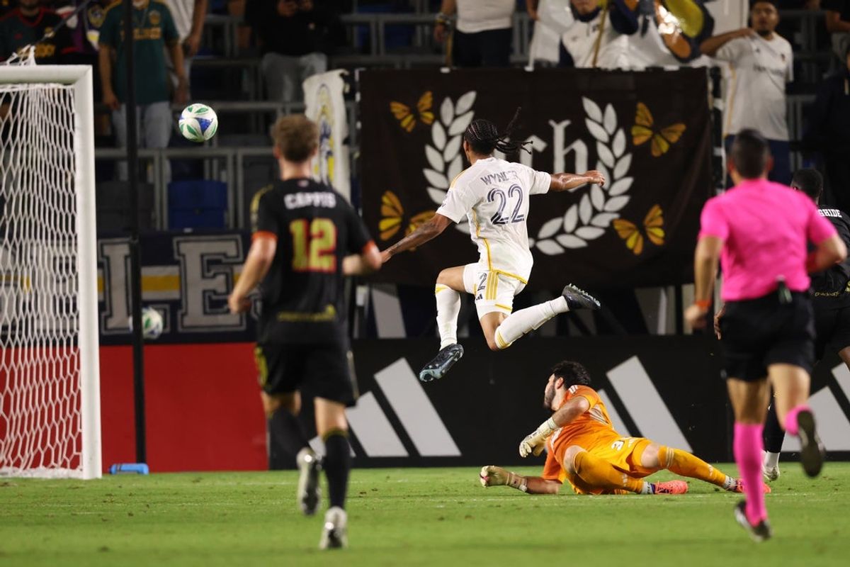 Oct 11, 2025; Carson, California, USA;  LA Galaxy midfielder Elijah Wynder (22) shoots and scores a goal against FC Dallas goalkeeper Michael Collodi (30) during the first half at Dignity Health Sports Park. Mandatory Credit: Kiyoshi Mio-Imagn Images