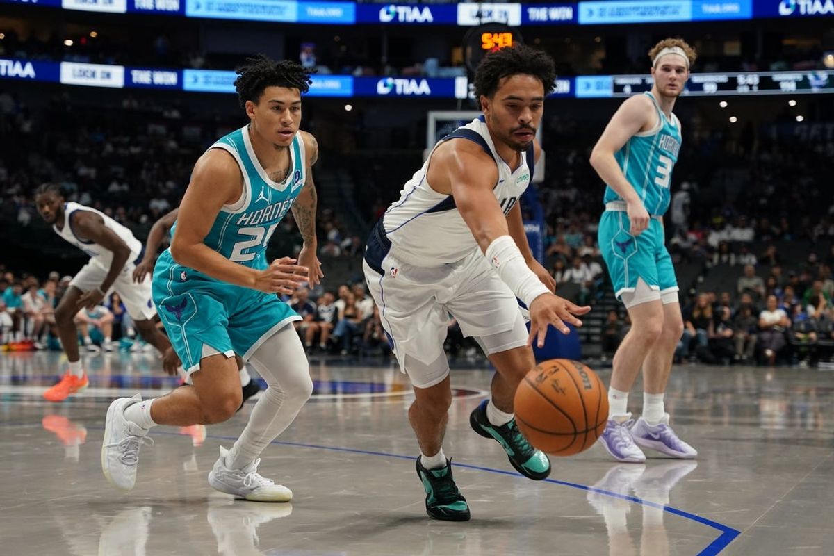 Oct 11, 2025; Dallas, Texas, USA; Dallas Mavericks guard Ryan Nembhard (9) reaches for the loose ball as Charlotte Hornets guard Spencer Dinwiddie (26) defends in the second half of a game at American Airlines Center. Mandatory Credit: Raymond Carlin III-Imagn Images