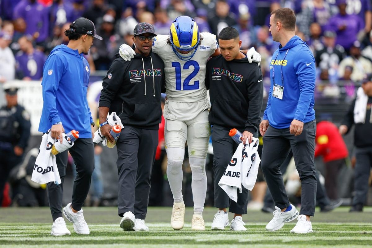 Oct 12, 2025; Baltimore, Maryland, USA; Los Angeles Rams wide receiver Puka Nacua (12) is helped off the field by trainers during the second quarter of the game against the Baltimore Ravens at M&T Bank Stadium. Mandatory Credit: Peter Casey-Imagn Images