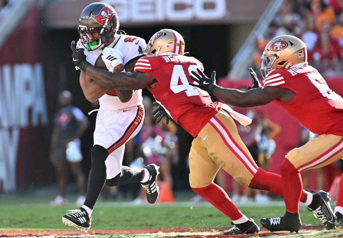 Oct 12, 2025; Tampa, Florida, USA: Tampa Bay Buccaneers wide receiver Emeka Egbuka (2) runs for a gain past San Francisco 49ers linebacker Tatum Bethune (48) during the second quarter at Raymond James Stadium. Mandatory Credit: Jonathan Dyer-Imagn Images