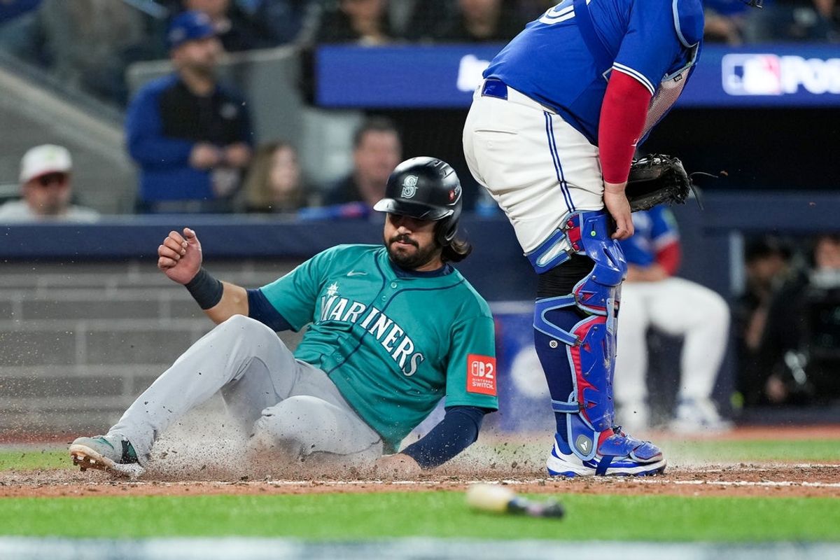 Oct 13, 2025; Toronto, Ontario, CAN; Seattle Mariners infielder Eugenio Suárez (28) scores on a sacrifice fly by in the seventh inning against the Toronto Blue Jays during game two of the ALCS round for the 2025 MLB playoffs at Rogers Centre. Mandatory Credit: Nick Turchiaro-Imagn Images