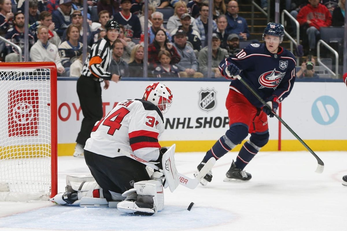 Oct 13, 2025; Columbus, Ohio, USA; New Jersey Devils goalie Jake Allen (34) makes a save as Columbus Blue Jackets left wing Dmitri Voronkov (10) looks for a rebound during the first period at Nationwide Arena. Mandatory Credit: Russell LaBounty-Imagn Images
