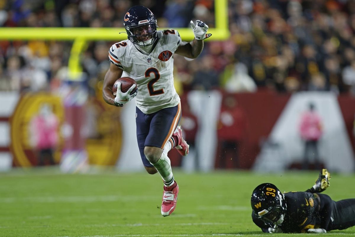 Oct 13, 2025; Landover, Maryland, USA; Chicago Bears wide receiver DJ Moore (2) escapes the tackle of Washington Commanders safety Jeremy Reaves (39) during the first quarter at Northwest Stadium. Mandatory Credit: Peter Casey-Imagn Images