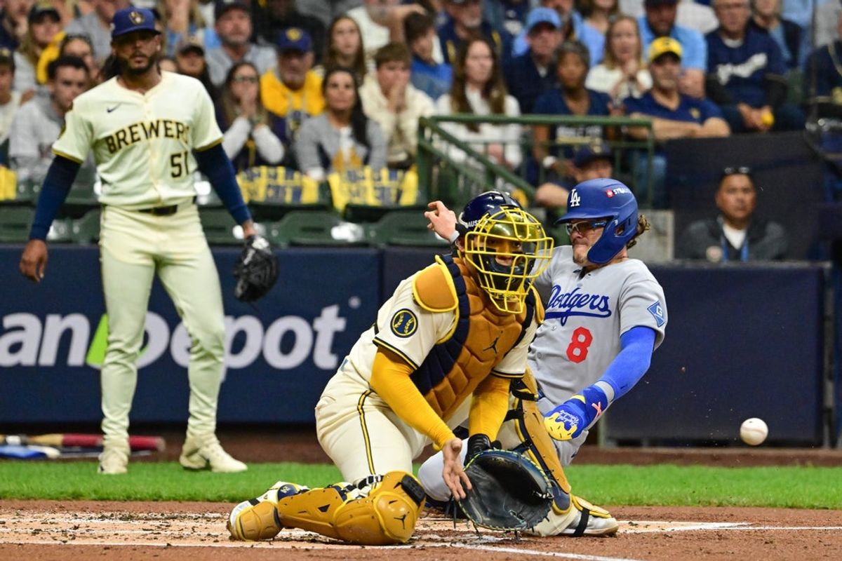 Oct 14, 2025; Milwaukee, Wisconsin, USA; Los Angeles Dodgers left fielder Enrique Hernandez (8) slides safely into home plate against Milwaukee Brewers catcher William Contreras (24) in the second inning during game two of the NLCS round for the 2025 MLB playoffs at American Family Field. Mandatory Credit: Benny Sieu-Imagn Images