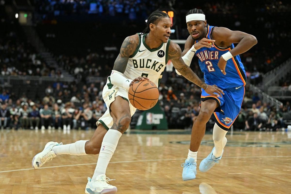 Oct 14, 2025; Milwaukee, Wisconsin, USA; Milwaukee Bucks guard/forward Kevin Porter Jr. (7) drives the ball against Oklahoma City Thunder guard Shai Gilgeous-Alexander (2) during the first half at Fiserv Forum. Mandatory Credit: Patrick Gorski-Imagn Images