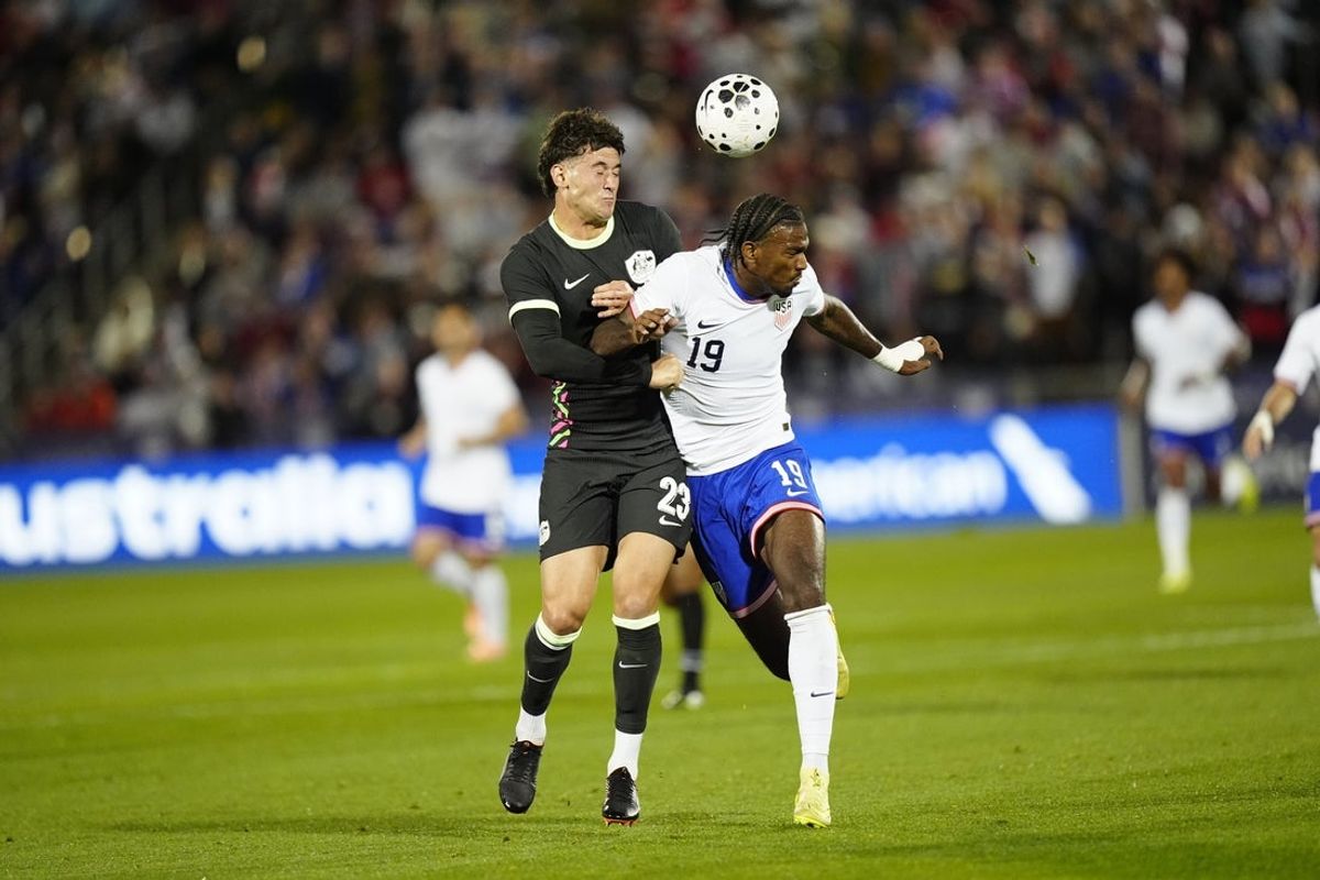 Oct 14, 2025; Commerce City, Colorado, USA; Australia defender Alessandro Circati (23) and USA forward Haji Wright19) reach for the ball in the first half at Dick's Sporting Goods Park. Mandatory Credit: Ron Chenoy-Imagn Images