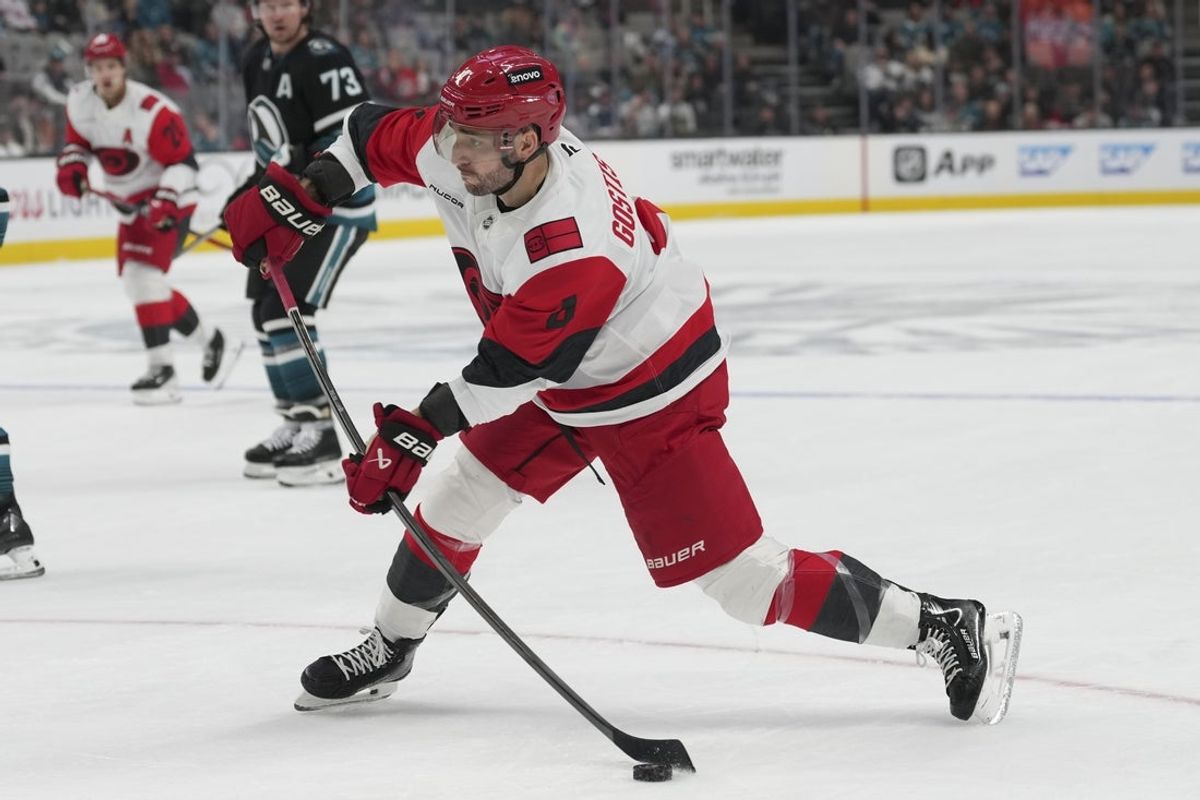 Oct 14, 2025; San Jose, California, USA;  Carolina Hurricanes defenseman Shayne Gostisbehere (4) prepares to shoot the puck during the second period against the San Jose Sharks at SAP Center at San Jose. Mandatory Credit: Stan Szeto-Imagn Images