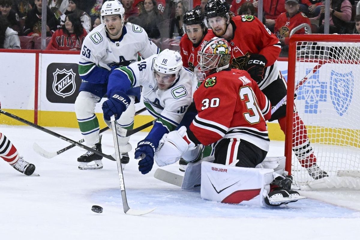 Oct 17, 2025; Chicago, Illinois, USA;  Vancouver Canucks left wing Drew O'Connor (18) shoots against Chicago Blackhawks goaltender Spencer Knight (30) during the first period at the United Center. Mandatory Credit: Matt Marton-Imagn Images
