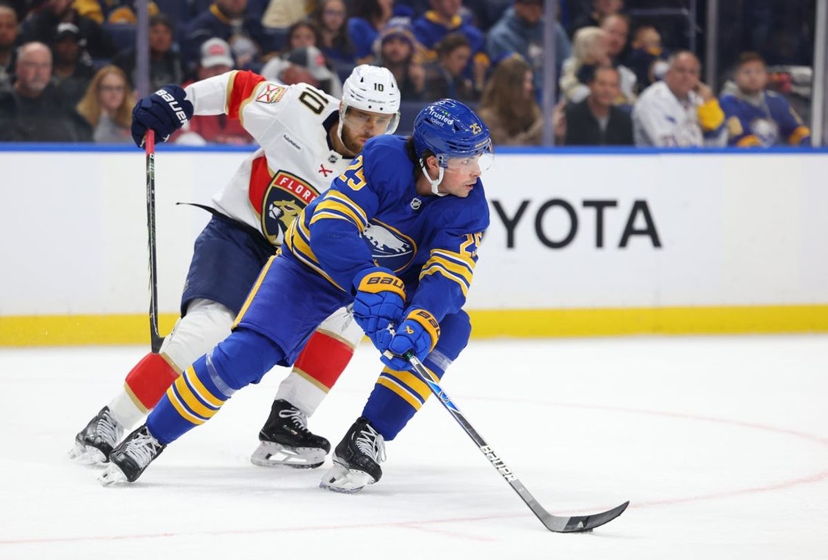 Oct 18, 2025; Buffalo, New York, USA;  Buffalo Sabres defenseman Owen Power (25) looks to clear the puck as Florida Panthers left wing A.J. Greer (10) defends during the first period at KeyBank Center. Mandatory Credit: Timothy T. Ludwig-Imagn Images