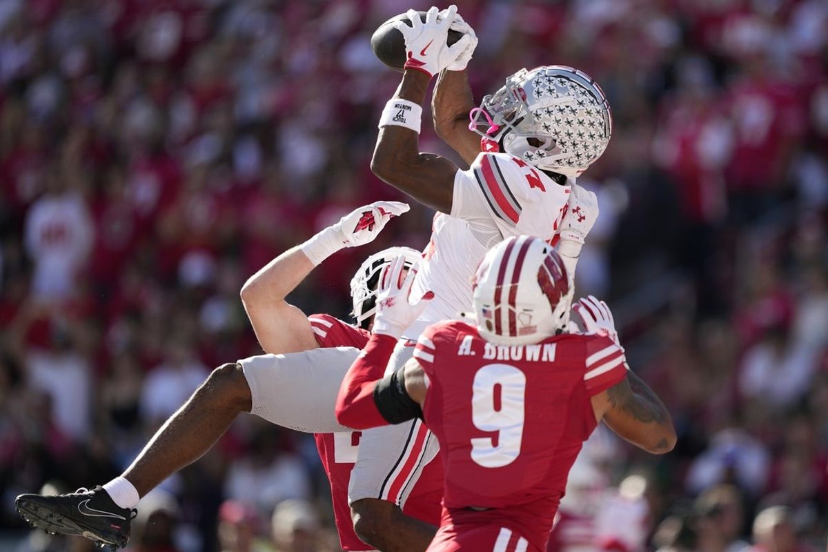 Oct 18, 2025; Madison, Wisconsin, USA; Ohio State Buckeyes wide receiver Carnell Tate (17) makes a catch for a touchdown against Wisconsin Badgers safety Austin Brown (9) in the first quarter at Camp Randall Stadium. Mandatory Credit: Jeff Hanisch-Imagn Images