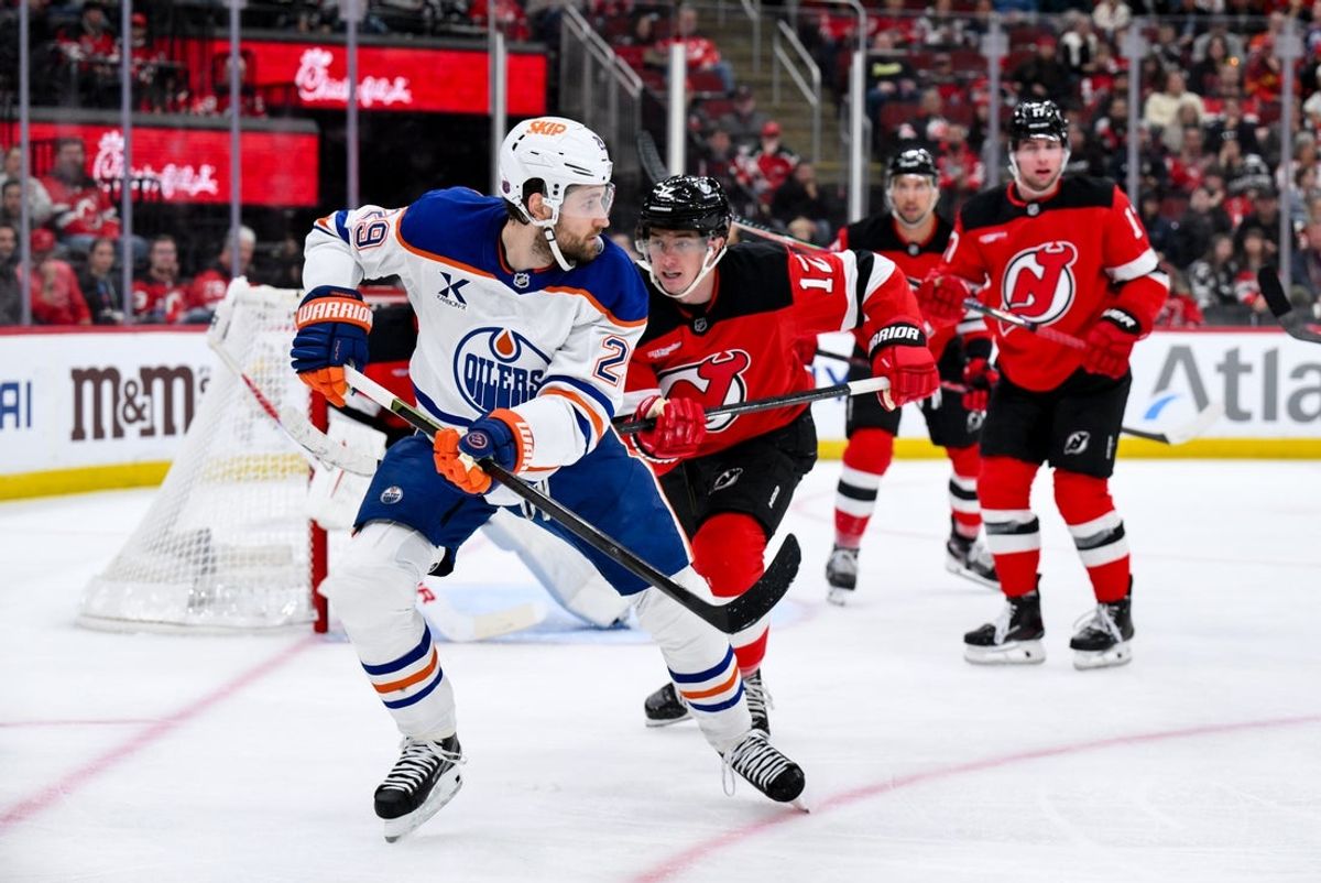 Oct 18, 2025; Newark, New Jersey, USA; Edmonton Oilers center Leon Draisaitl (29) skates against New Jersey Devils center Cody Glass (12) during the first period at Prudential Center. Mandatory Credit: John Jones-Imagn Images