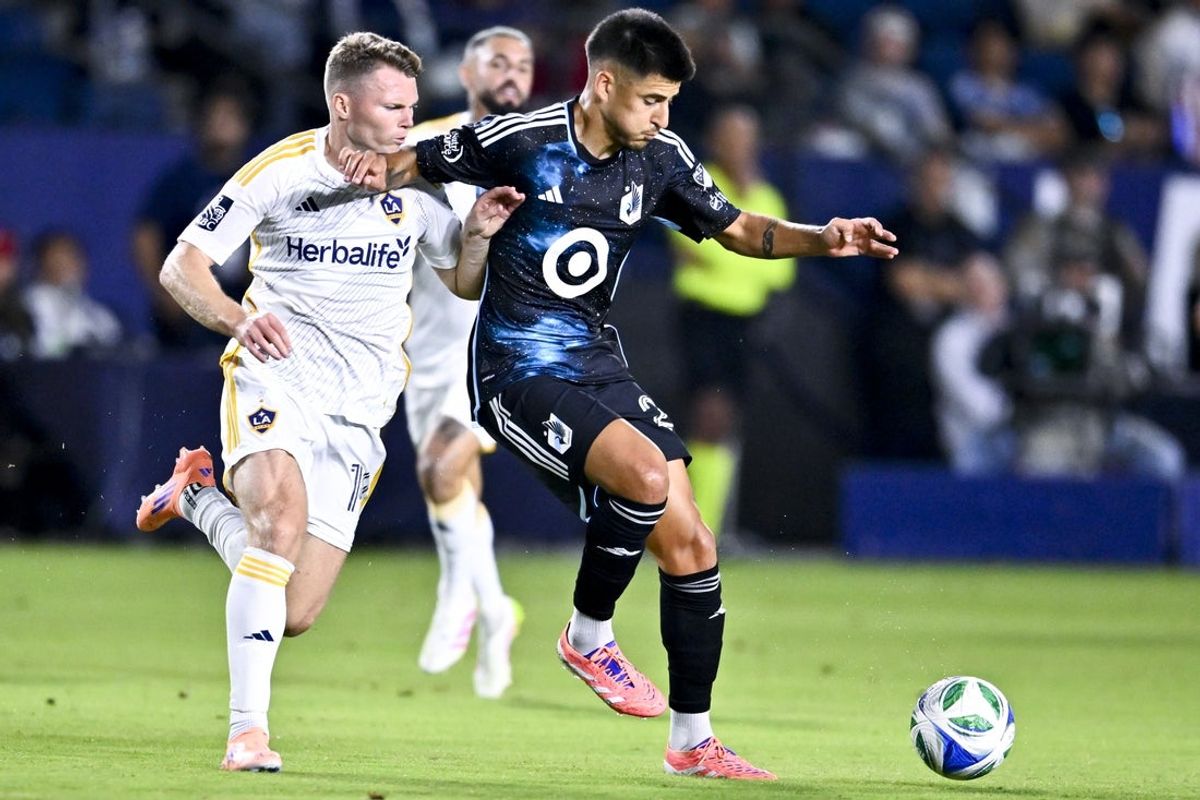 Oct 18, 2025; Carson, California, USA; LA Galaxy defender John Nelson (14) defends against Minnesota United FC midfielder Joaquín Pereyra (26) during the first half at Dignity Health Sports Park. Mandatory Credit: Kelvin Kuo-Imagn Images