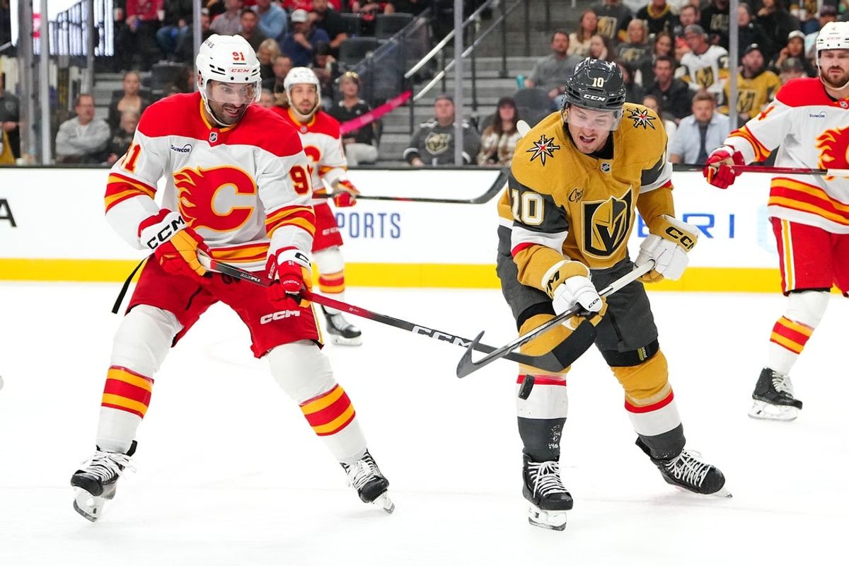 Oct 18, 2025; Las Vegas, Nevada, USA; Vegas Golden Knights center Colton Sissons (10) battles against Calgary Flames center Nazem Kadri (91) for a loose puck during the second period at T-Mobile Arena. Mandatory Credit: Stephen R. Sylvanie-Imagn Images