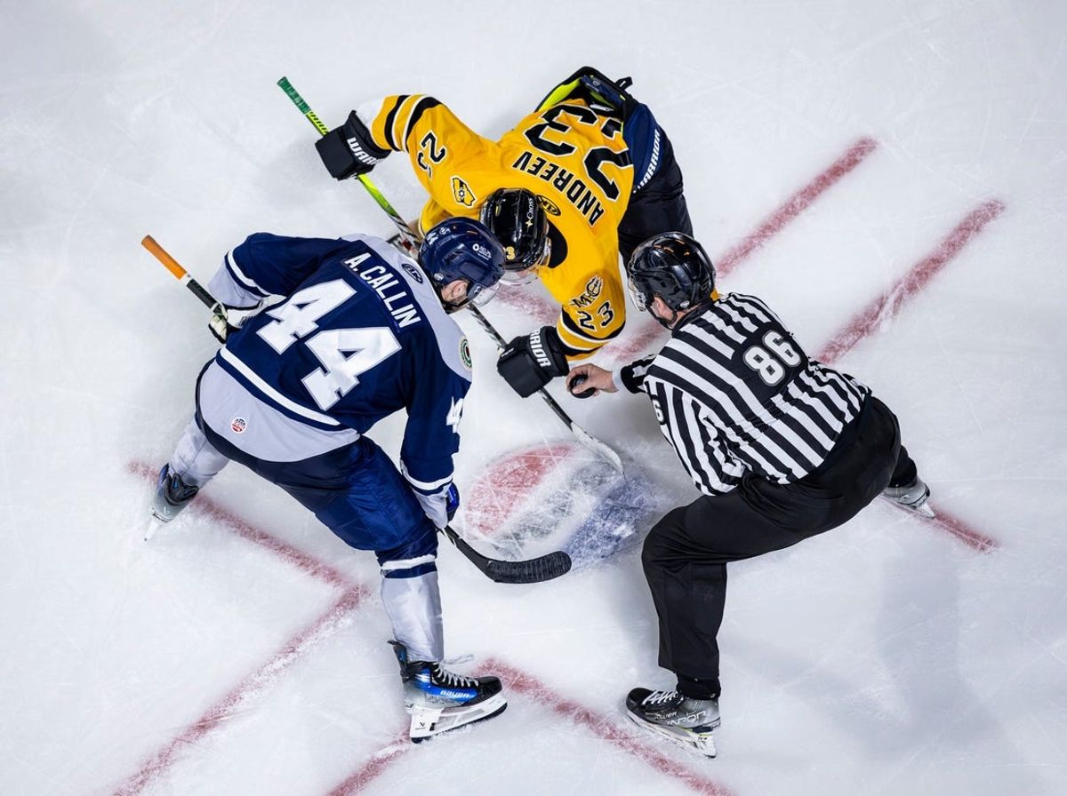 Worcester Railers' Anthony Callin, left, and Maine Mariners Max Andreev prepare for the puck to drop to start the game - and 2025-26 ECHL season - for the two squads.