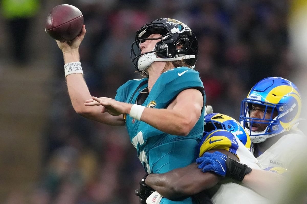 Oct 19, 2025; London, United Kingdom; Los Angeles Rams linebacker Bryon Young (0) tackles Jacksonville Jaguars quarterback Trevor Lawrence (16) during the second half of an NFL International Series game at Wembley Stadium. Mandatory Credit: Kirby Lee-Imagn Images