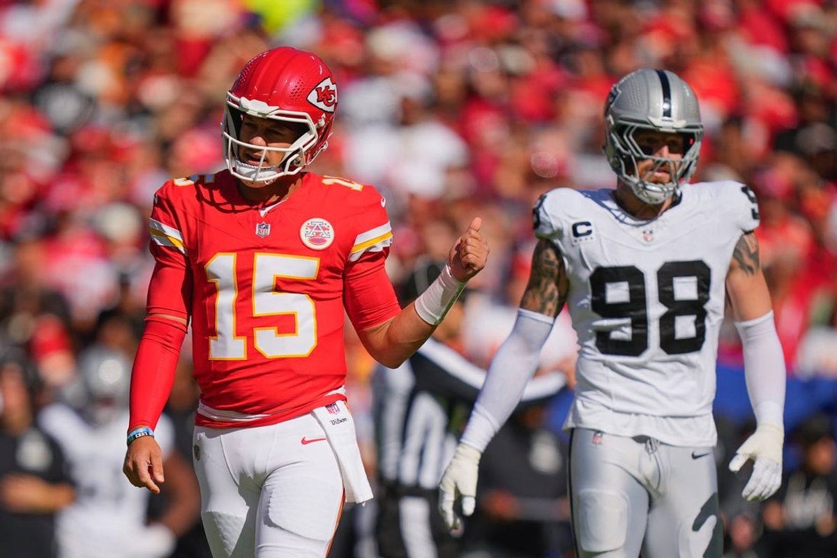 Oct 19, 2025; Kansas City, Missouri, USA; Kansas City Chiefs quarterback Patrick Mahomes (15) gestures as Las Vegas Raiders defensive end Maxx Crosby (98) looks on during the first quarter of the game at GEHA Field at Arrowhead Stadium. Mandatory Credit: Jay Biggerstaff-Imagn Images