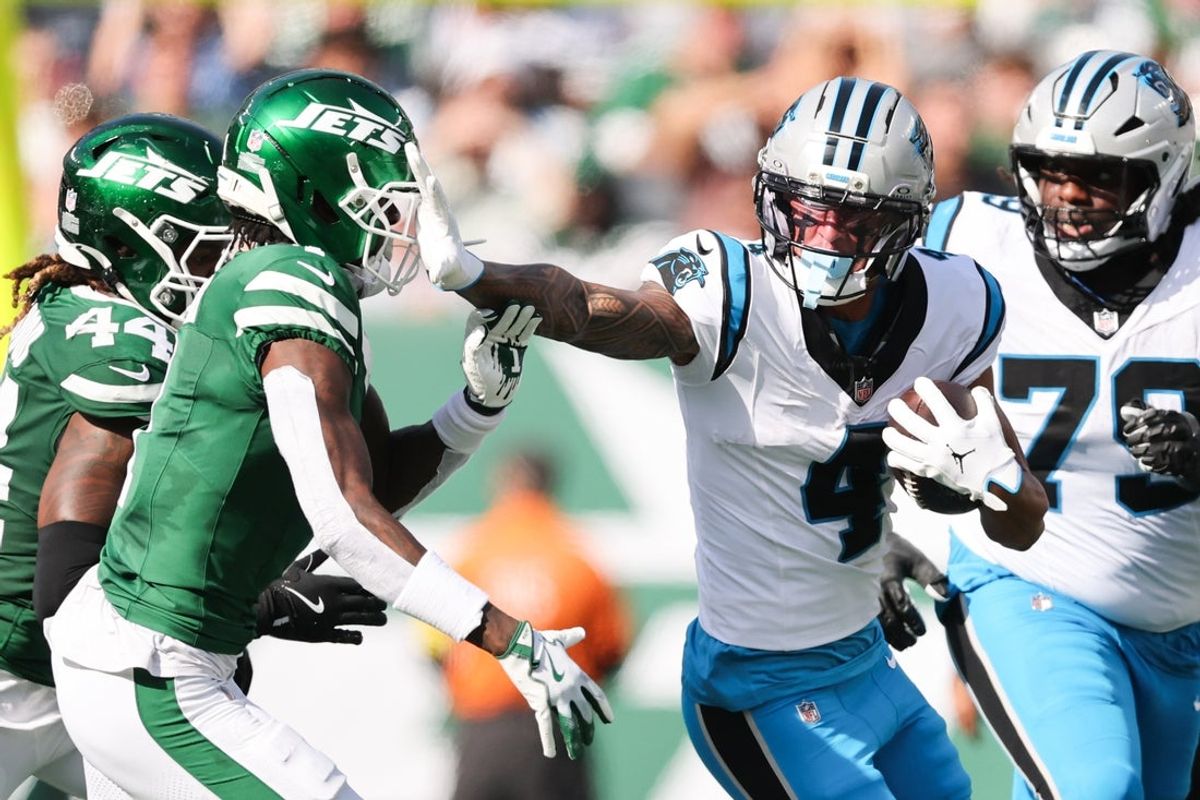 Oct 19, 2025; East Rutherford, New Jersey, USA; Carolina Panthers wide receiver Tetairoa McMillan (4) stiff arms New York Jets cornerback Sauce Gardner (1) in the second quarter at MetLife Stadium. Mandatory Credit: Vincent Carchietta-Imagn Images