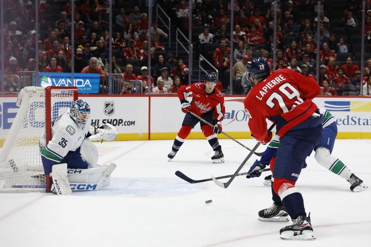 Oct 19, 2025; Washington, District of Columbia, USA; Washington Capitals center Hendrix Lapierre (29) passes the puck to Capitals defenseman Jakob Chychrun (6) prior to a goal on Vancouver Canucks goaltender Thatcher Demko (35) during the third period at Capital One Arena. Mandatory Credit: Geoff Burke-Imagn Images