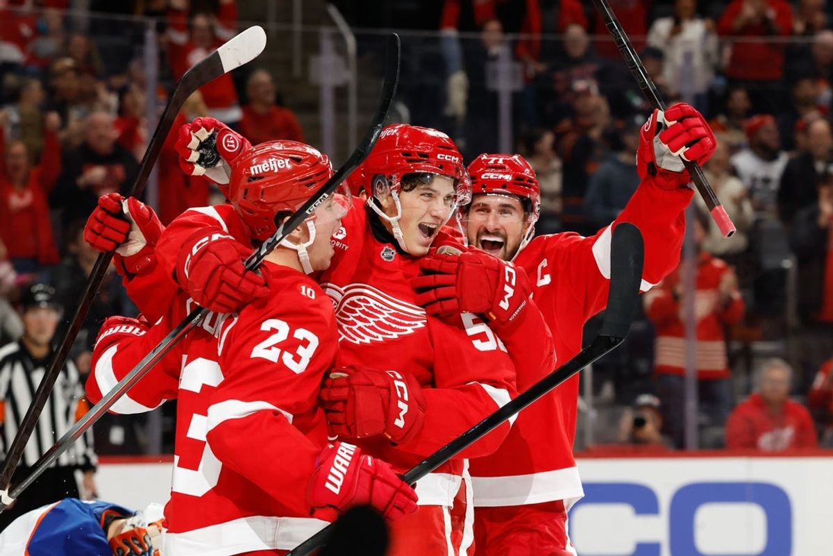 Oct 19, 2025; Detroit, Michigan, USA;  Detroit Red Wings center Emmitt Finnie (58) celebrates with left wing Lucas Raymond (23) and center Dylan Larkin (71) after scoring a goal against the Edmonton Oilers during the second period at Little Caesars Arena. Mandatory Credit: Rick Osentoski-Imagn Images