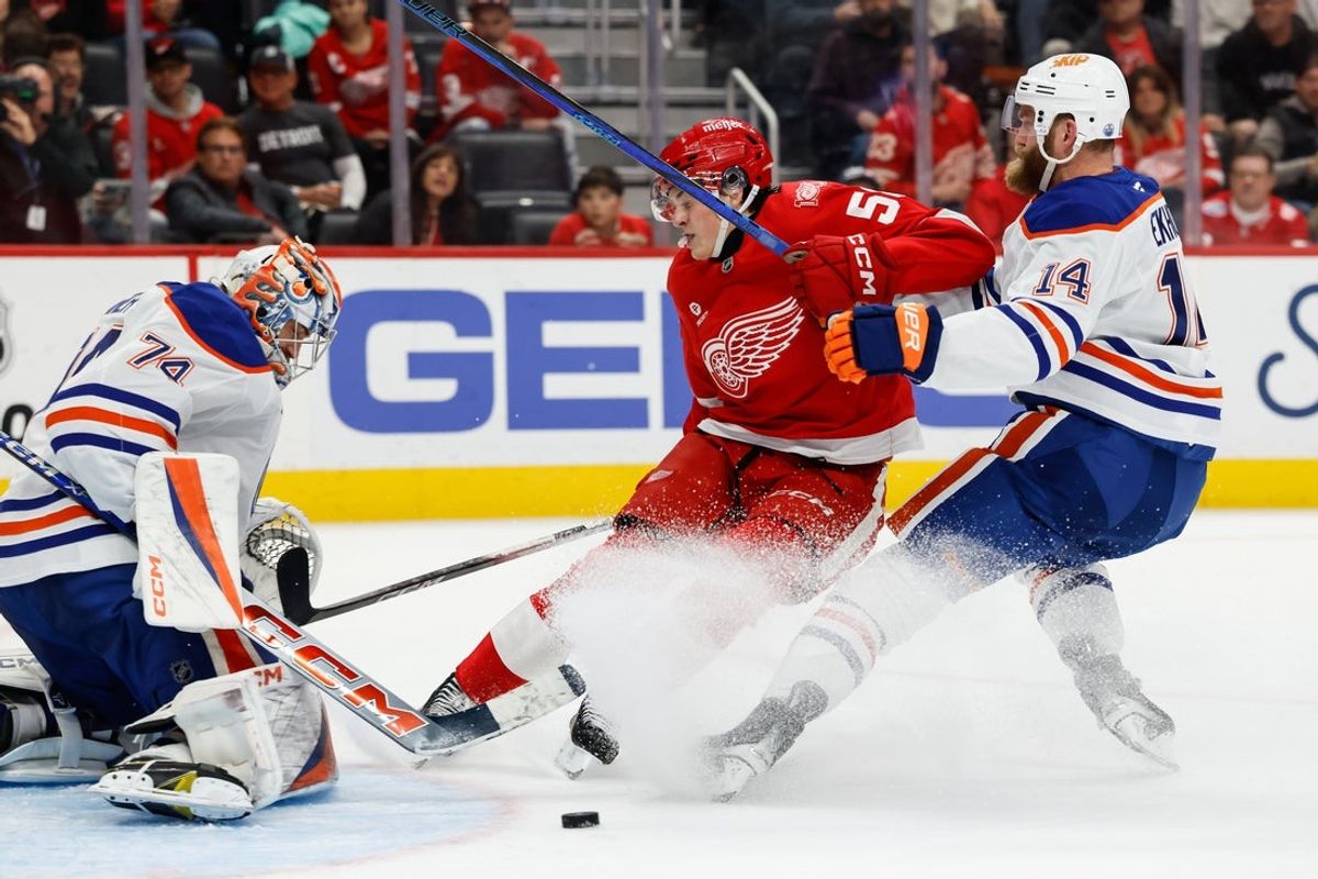 Oct 19, 2025; Detroit, Michigan, USA;  Edmonton Oilers goaltender Stuart Skinner (74) makes a save and defenseman Mattias Ekholm (14) defends against Detroit Red Wings center Emmitt Finnie (58) in the second period at Little Caesars Arena. Mandatory Credit: Rick Osentoski-Imagn Images