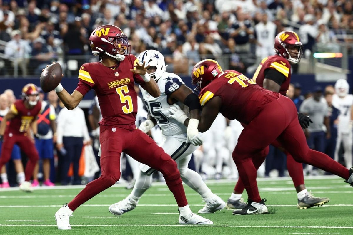 Oct 19, 2025; Arlington, Texas, USA; Washington Commanders quarterback Jayden Daniels (5) passes the ball under pressure from Dallas Cowboys nose tackle Kenny Clark (95) during the second quarter of the game at AT&T Stadium. Mandatory Credit: Kevin Jairaj-Imagn Images
