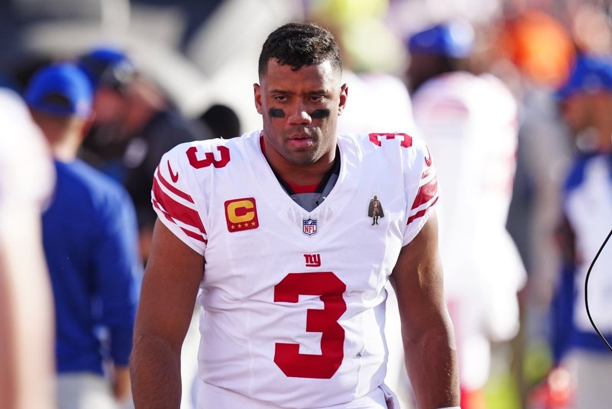 Oct 19, 2025; Denver, Colorado, USA; New York Giants quarterback Russell Wilson (3) looks on from the sidelines during the second half against the Denver Broncos at Empower Field at Mile High. Mandatory Credit: Ron Chenoy-Imagn Images