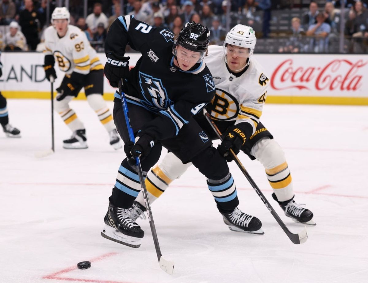 Oct 19, 2025; Salt Lake City, Utah, USA; Utah Mammoth center Logan Cooley (92) and Boston Bruins defenseman Jordan Harris (43) play for the puck during the first period at Delta Center. Mandatory Credit: Rob Gray-Imagn Images