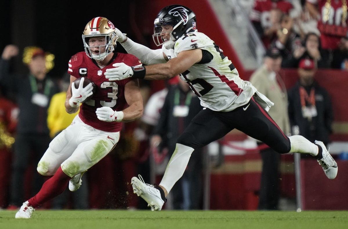Oct 19, 2025; Santa Clara, California, USA; San Francisco 49ers running back Christian McCaffrey (23) runs the ball against Atlanta Falcons linebacker Kaden Elliss (55) during the fourth quarter at Levi's Stadium. Mandatory Credit: Kyle Terada-Imagn Images