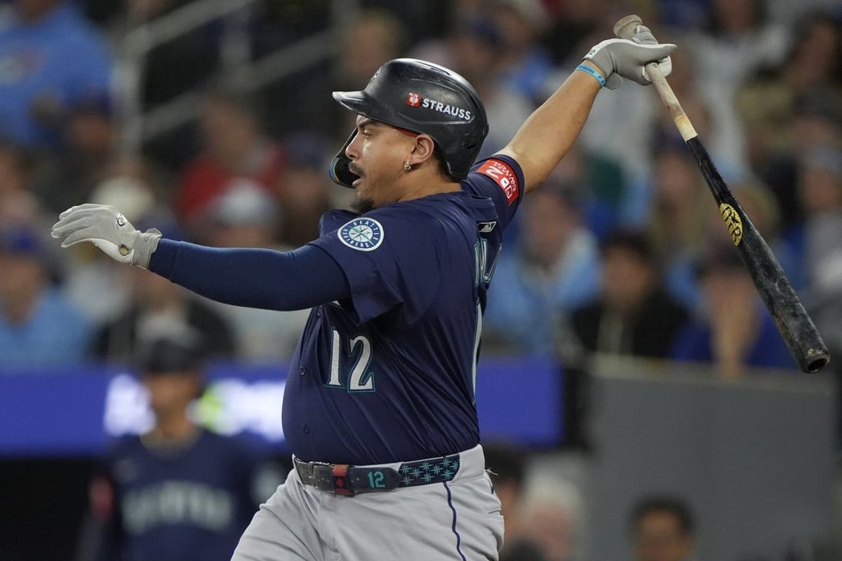 Oct 20, 2025; Toronto, Ontario, CAN; Seattle Mariners first baseman Josh Naylor (12) hits an RBI single against the Toronto Blue Jays in the first inning during game seven of the ALCS round for the 2025 MLB playoffs at Rogers Centre. Mandatory Credit: John E. Sokolowski-Imagn Images