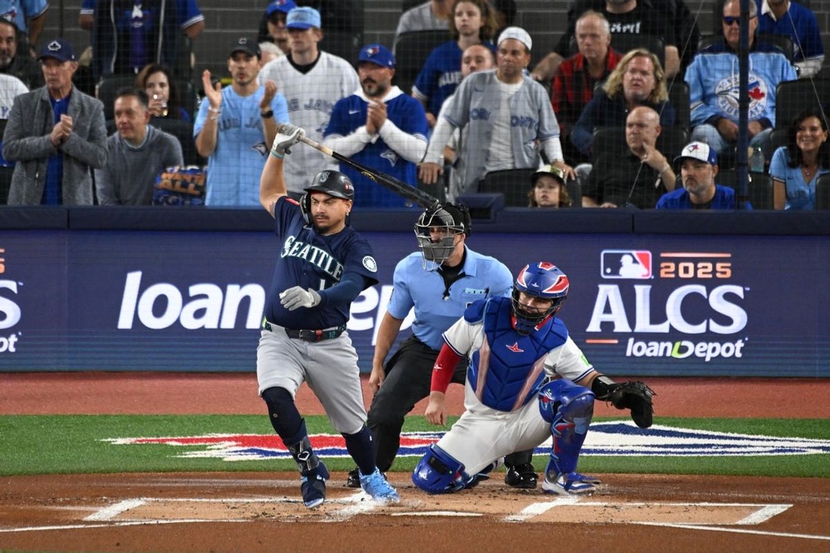 Oct 20, 2025; Toronto, Ontario, CAN; Seattle Mariners first baseman Josh Naylor (12) hits an RBI single against the Toronto Blue Jays in the first inning during game seven of the ALCS round for the 2025 MLB playoffs at Rogers Centre. Mandatory Credit: Dan Hamilton-Imagn Images