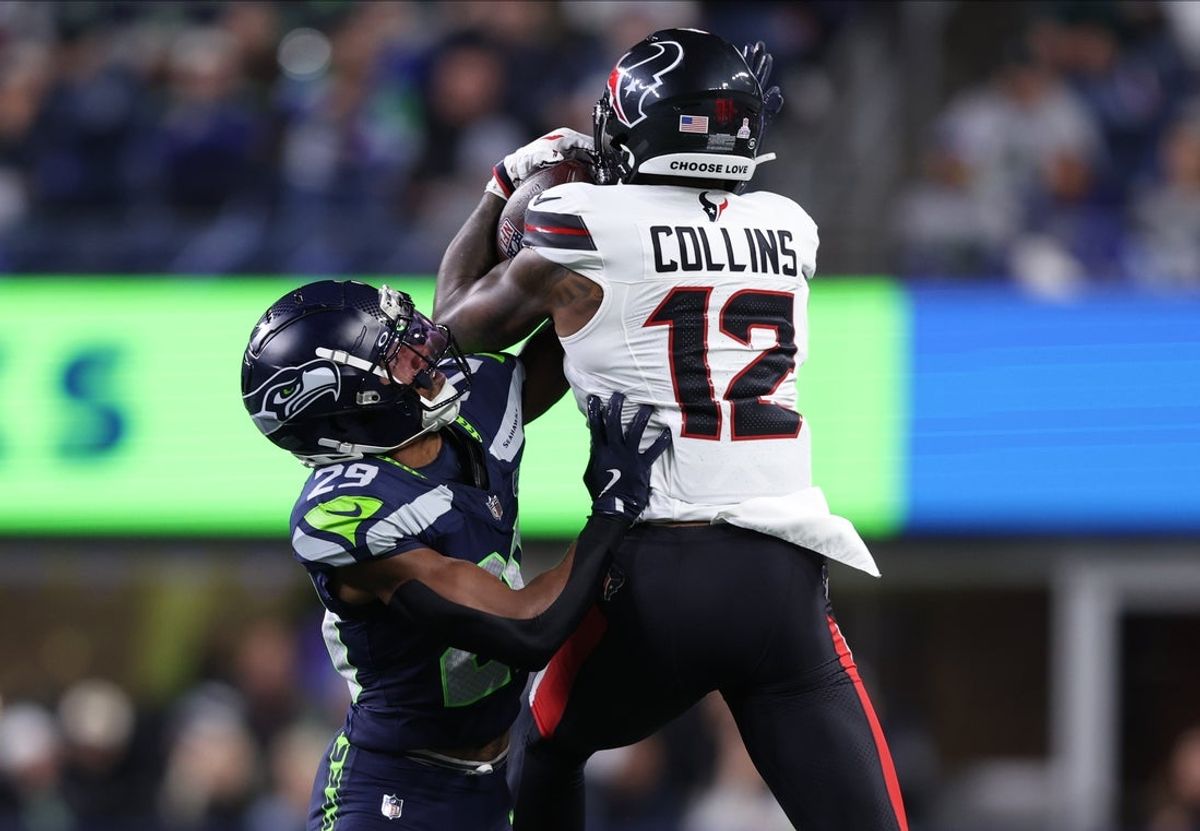 Oct 20, 2025; Seattle, Washington, USA; Houston Texans wide receiver Nico Collins (12) catches a pass against Seattle Seahawks cornerback Josh Jobe (29) during the second quarter at Lumen Field. Mandatory Credit: Kevin Ng-Imagn Images